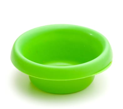 Green colored plastic pet bowl with a few remnants of food, but empty