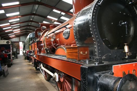 steam train in a train shed with a wooden box on board