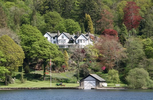 large white house amongst the trees with a beautiful landscape garden