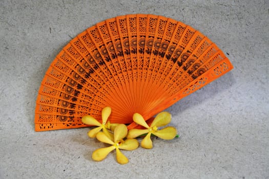 Bright orange Asian fan with yellow orchids.