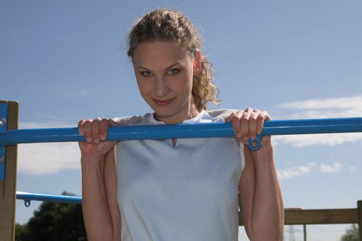 Pretty blond woman doing exercises in the park