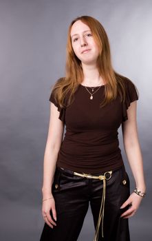 The young girl in brown shirt-blouse on a grey background