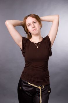 The young girl in brown shirt-blouse on a grey background