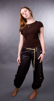 The young girl in brown shirt-blouse on a grey background