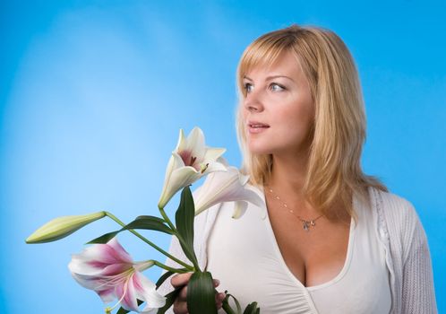 The attractive woman holds a liliy in hands