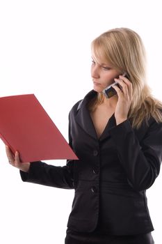 The businesswoman reads documents and speaks by phone.