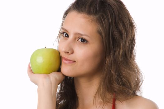 The brown-eyed girl holds a green apple in hands