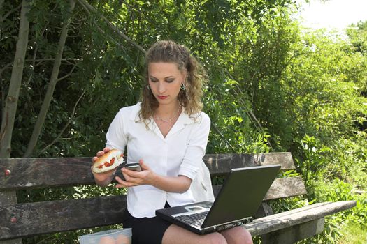 Pretty businesswoman in the park having a healthy lunch