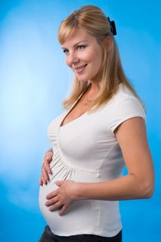 The fine pregnant woman supports hands a stomach.