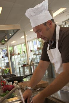 Italian chef cleaning his knife after having chopped the onions