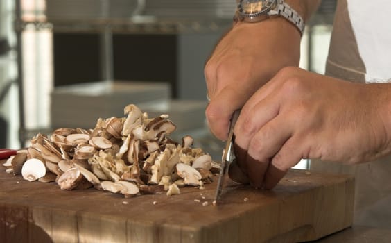 Male hands cutting the mushrooms into slices