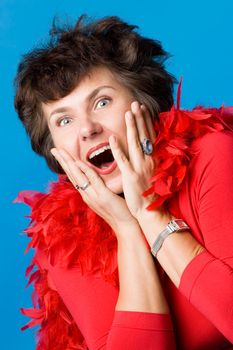 The attractive woman in a red dress and a boa is very surprised