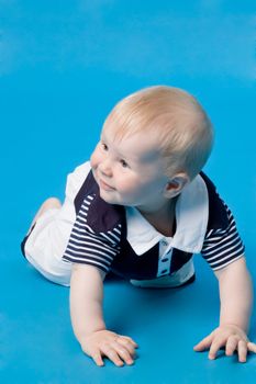 The small smiling child in studio, on a blue background
