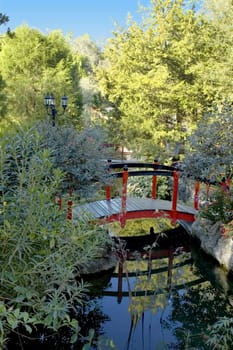 A oriental-style red bridge traverses pools made by old limerock mine pits.