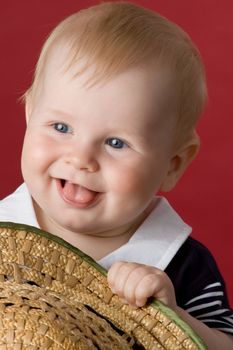 The small smiling child in studio, on a red background