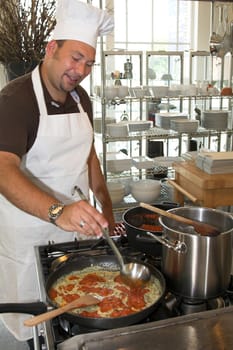 Italian man cooking pasta in the restaurant kitchen