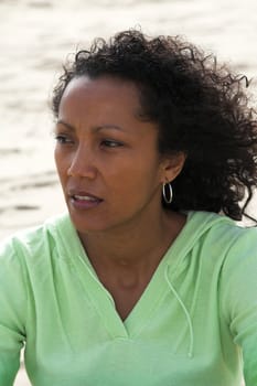 Beautiful black woman on the beach with a thoughtful look