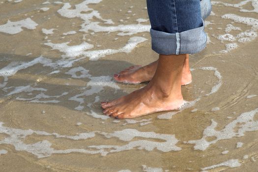 Pretty woman standing barefoot in the sea