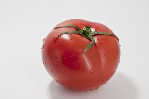 fresh red tomatoes in a heap on a light background