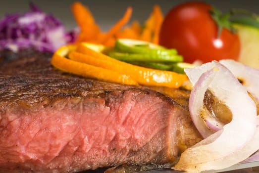 fresh juicy beef ribeye steak sliced ,with lemon and orange peel on top  and vegetable beside