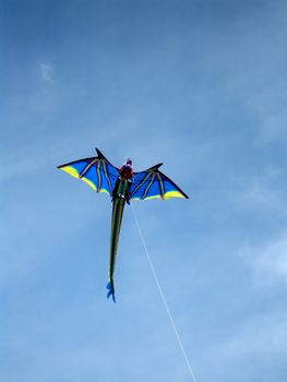 Dragon kite flying in a natural cloudy blue sky background