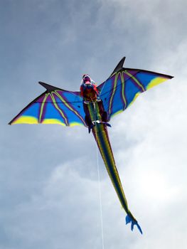 Dragon kite flying in blue cloudy sky