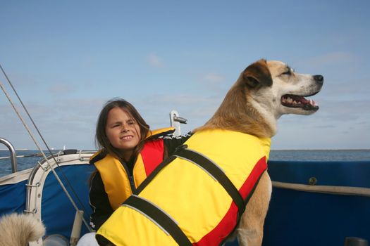 Akita and Australian shepard mixed breed dog and girl sailing across the water