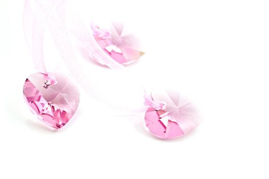 Three pink crystal hearts on a white background.
