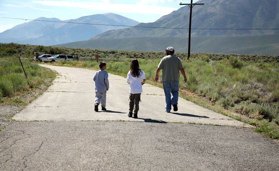 Family strolling down a road towards their vehicle