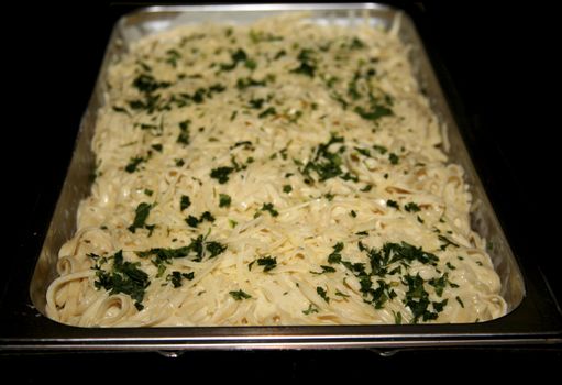 Delicious fettuccine alfredo in a large serving pan at a buffet