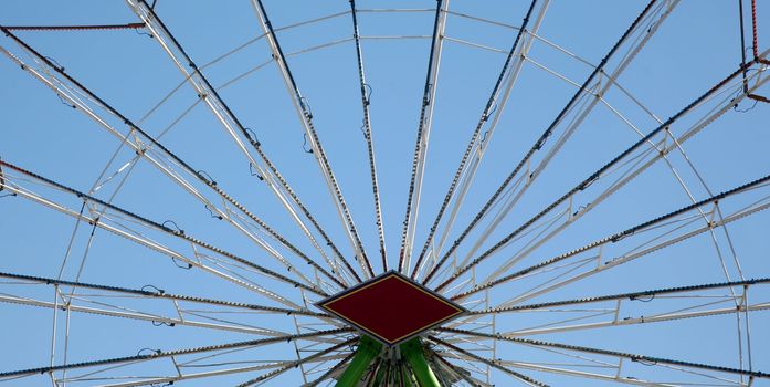 Carnival ferris wheel spokes with clear sky