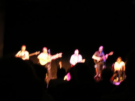 blurred group as they perform on stage