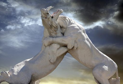 Statue of fighting lions with dark sky