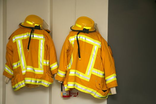 Firefighter jackets and helmets hanging in the fire station