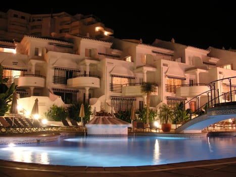 lit pool outside apartments at night