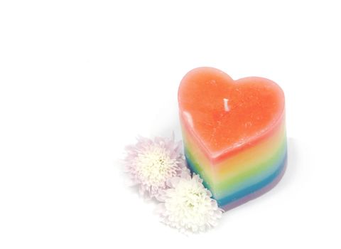 multi coloured candle with flowers against a white background