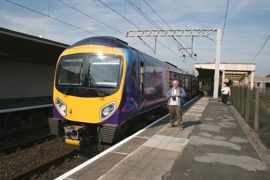 modern diesel train and  train spotters at a  train station