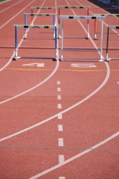 hurdles on a runners track with running lanes