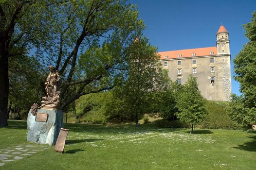 bratislava castle in background, woman sculpture in foreground, park