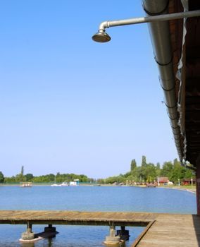 shower outdoor by blue lake with wooden pier