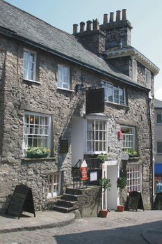 very old stone built buildings of shops and cobbled street