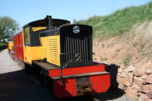 yellow shunter train pulling wagons along the track