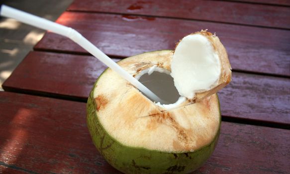Open coco, milk, tropical cocktail on wooden table