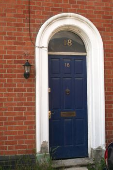 blue door in a arched doorway with glass above the door