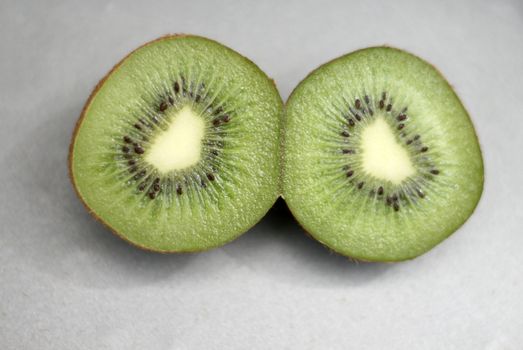 kiwi fruit cut in half showing the seeds and juice of the fruit