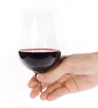 Hand holding glass of red whine. Studio shot. White background.