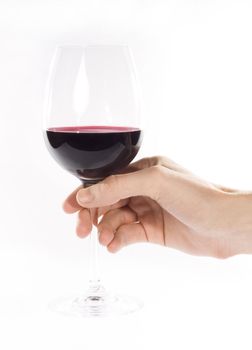 Hand holding glass of red whine. Studio shot. White background.