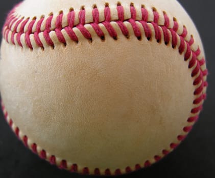 A baseball seen up close and on a black background