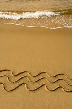 three waves in sand on a beach, water wave in background
