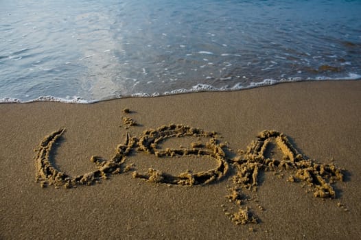 USA written in sand on a beach, calm water 